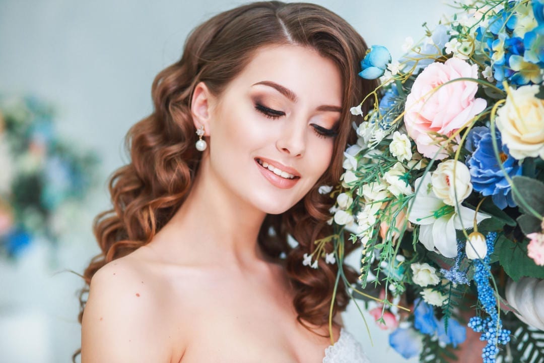 Beautiful young bride with wedding makeup and hairstyle indoor .Closeup portrait of young gorgeous bride in studio