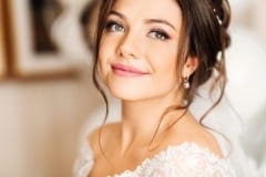 Beautiful bride with fashion wedding hairstyle - on white background.Closeup portrait of young gorgeous bride. Wedding. Studio shot.Beautiful bride portrait with veil over her face