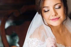 Beautiful bride with fashion wedding hairstyle - on white background.Closeup portrait of young gorgeous bride. Wedding. Studio shot.Beautiful bride portrait with veil over her face