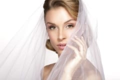 portrait of  young woman in wedding dress posing with white brid